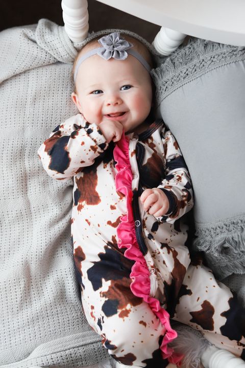 Cow printed footie sleeper with light pink ruffles